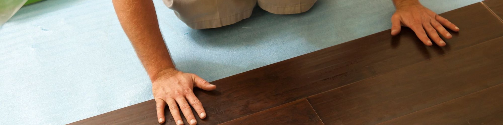 man laying down hardwood flooring - Cut-Rite Carpets & Design Center in Scarsdale, NY